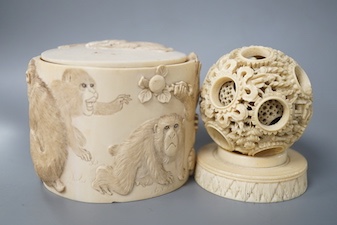 A late 19th century Chinese carved ivory concentric ball comprising seven reticulated spheres, with a small stand, and a Japanese carved ivory box (base missing), Meiji period, of cylindrical form, decorated with a black